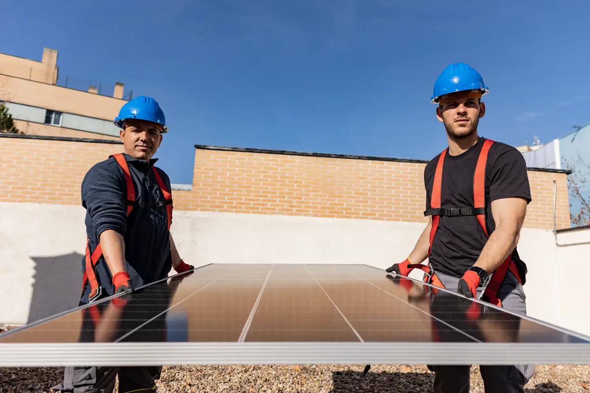Deux ouvriers de la construction installant un panneau solaire